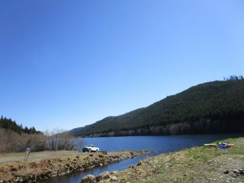 A few people swimming and fishing at the far end.